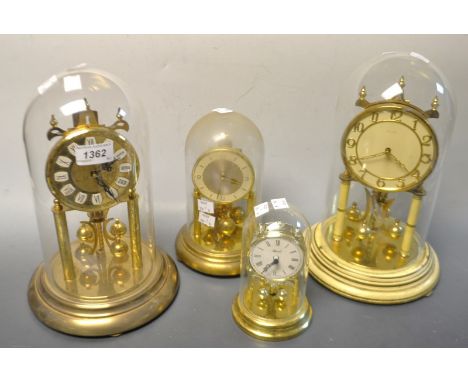 A Kundo anniversary clock, glass dome; others smaller (4)
