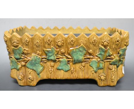 An English majolica planter, applied in relief with ivy, the ground in the form of a rustic fence, castellated rim, 37cm wide