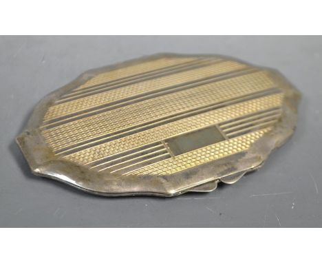 A lady's silver shaped oval powder compact, engine turned, vacant cartouche, Birmingham 1944, 10cm wide