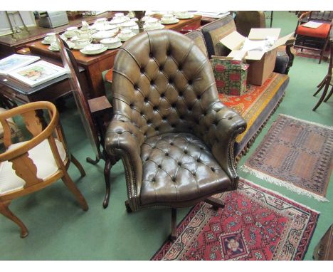 An olive green leather button back and seat swivel office chair on castors