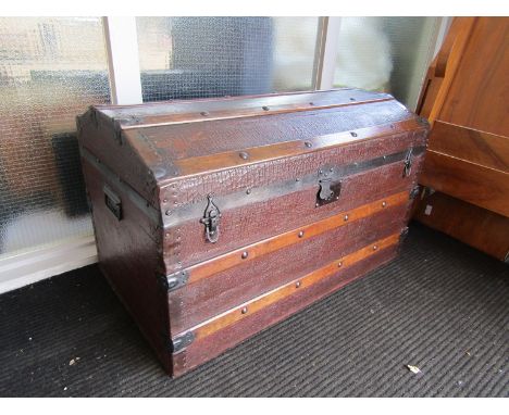 A domed travel trunk with red velour interior, wooden banding and metal handles, 91cm x 56cm x 50cm