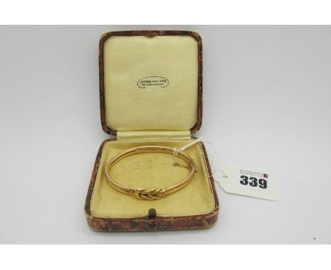 A Knot Style Bangle, of openwork design to snap clasp, and safety chain, indistinctly stamped "15ct" (11grams)