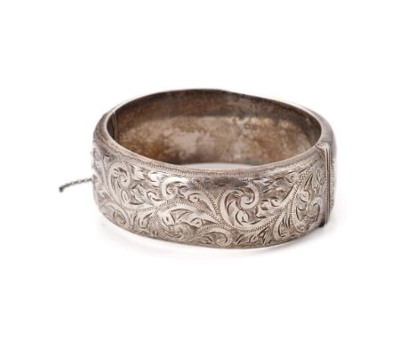 Vintage silver bangle with hand chased repeated design and safety chain. Weight 42.6 grams.  