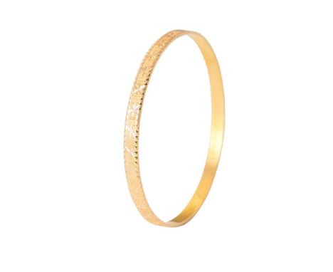 Yellow metal (tests as 18ct or better) circular bangle with engraved decoration, 61mm diameter, 14.0 grams.  