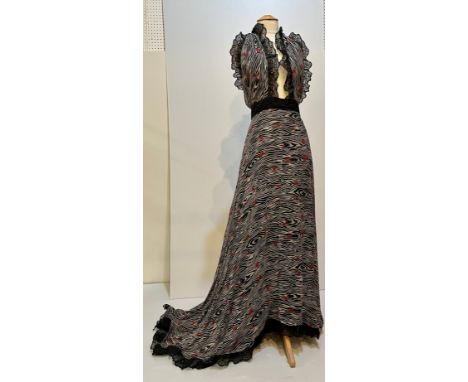 A black full length dress with tie bodice, plunging back and front, and train to skirt at the back. Printed pattern on chiffo