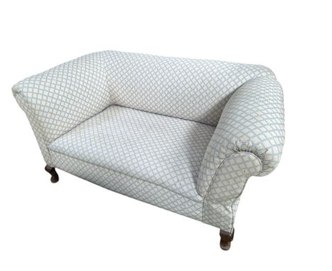 A small two seater drop end sofa, raised on four legs, some wear and dirt, for re-upholstery