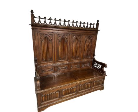 A large gothic style high backed bench, with rising lid seat, and four decorative arched panels to back, 189cm High x  176cm 