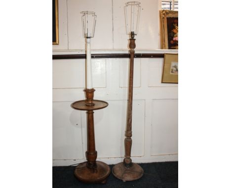 An oak standard lamp on baluster support with central circular shelf, on circular domed base and bun feet, together with anot