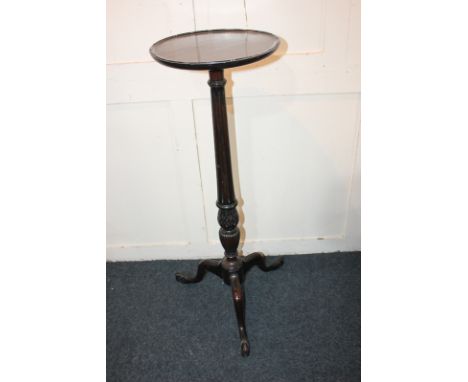 A mahogany jardiniere stand with circular top on carved foliated baluster stem and tripod base, 90cm high