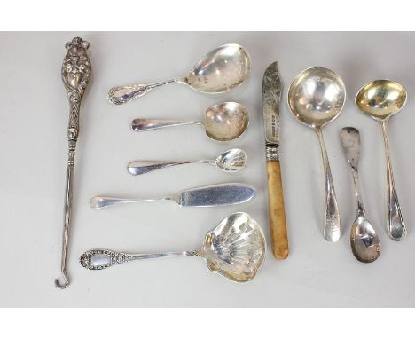 An Edward VII silver caddy spoon, sifter spoon, small ladle, various cruet spoons, and a button hook with embossed scroll han