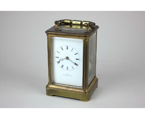 A late 19th century brass carriage clock with white enamel dial and Roman numerals, marked Dent of London, the movement strik
