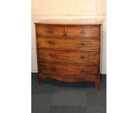 A George III mahogany bowfront chest of two short over three long drawers with brass drop handles, curved apron on splayed br