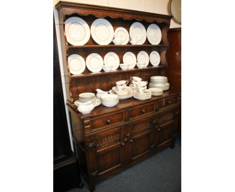 A 20th century oak Welsh dresser with two-shelf back, on base with three drawers and three carved cupboards, raised on block 