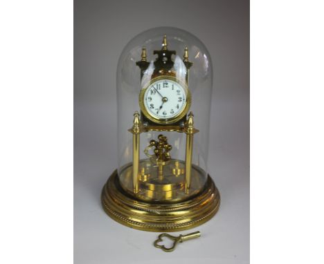 A brass anniversary clock marked 'Made in Germany', under glass dome (a/f), 31cm, with key