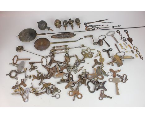 A collection of clock keys, finials, pendulums and clock parts