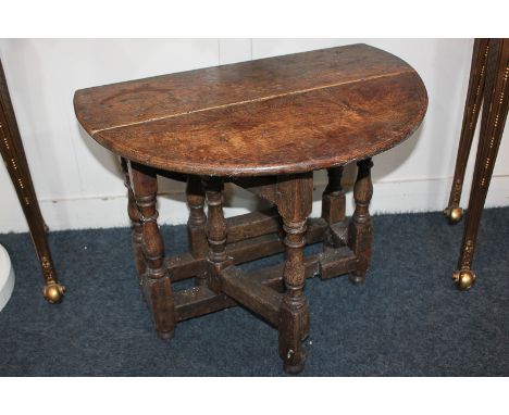 A small oak oval drop-leaf gate leg side table on turned supports, 66cm