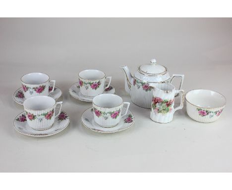 A child's toy porcelain tea set with pink floral decoration on white ground, comprising teapot, milk jug, sugar bowl and four