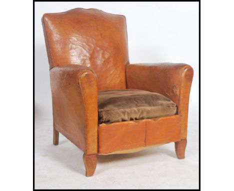 A 1930's Art Deco tan full grain leather moustache back French club armchair having barrel arms and fabulous shaped moustache