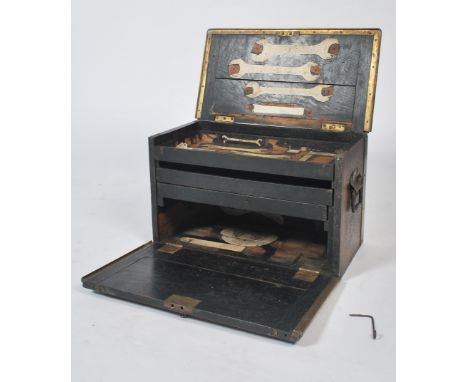 A mid century work / tool box comprising of an ebonised oak frame being brass bound. The interior having three drawers and eb