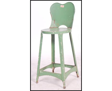 An early 20th century Industrial metal machinists stool / chair. Painted green with peripheral stretcher having panel seat an