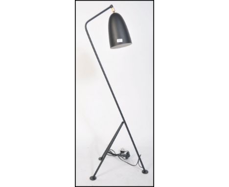 After Greta Grossman, a large black grasshopper floor lamp. Having a tubular steel tripod frame with tilt action having conic