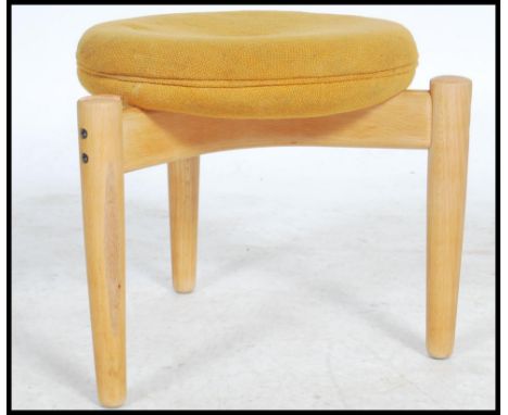 A good mid century design stool being raised on shaped leg base united by returns of cross form having an upholstered top abo