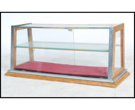 A superb point of sale / showcase display cabinet in light oak and metal bound, the cabinet has a single sliding door to the 