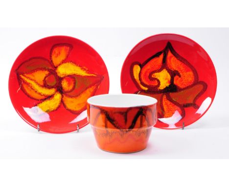 Three 1970s Poole pottery Delphis patterned pieces comprised of a bowl and two plates in a red and orange colourway. Poole ma