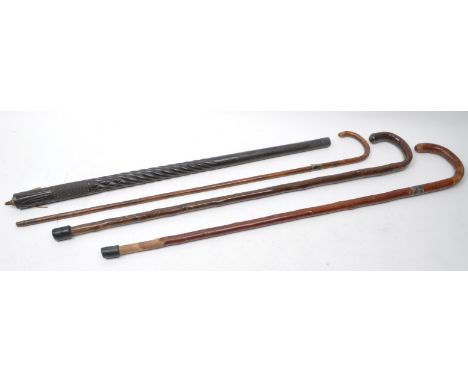 Four late 19th / early 20th century walking sticks, one bamboo example, two carved birch wooden sticks with rubber ferrules a