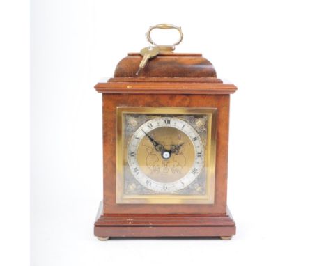 Garrard and Co - 1980 London bracket clock housed in a wooden case with brass clock face including relief cherubs to each cor