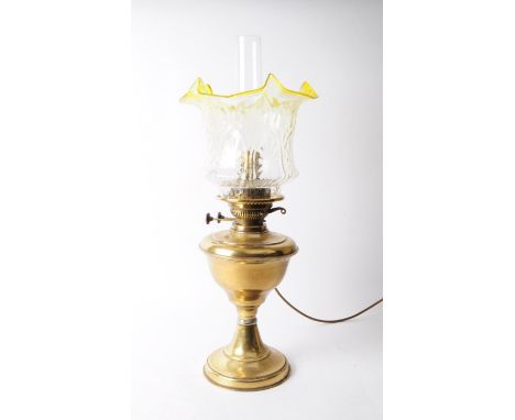 Early 20th century brass oil lamp with glass shade and reservoir. Glass shade in a clear textured flower shape with a yellow 