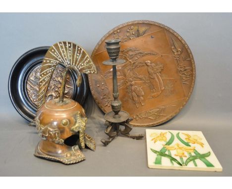 A Meiji Period Patinated Charger Decorated In Relief With Figs Within A Landscape, together with another relief decorated pla