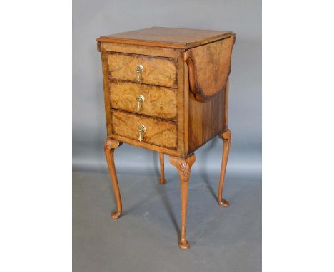 A 1920's Burr Walnut Queen Anne Style Lamp Table By Maple &amp; Co, the shaped drop flap top above three drawers with brass d