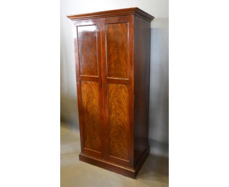 An Edwardian Mahogany Hall Cupboard, The Moulded Cornice above two moulded panelled doors, raised upon bracket feet, 86cm wid