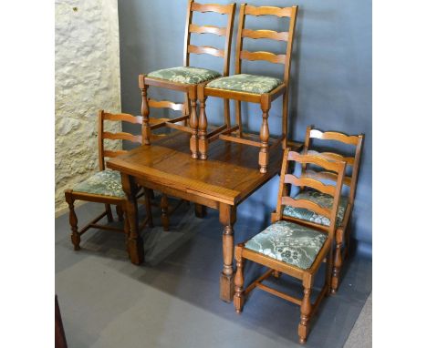 An Oak Dining Room Suite Comprising Draw Leaf Table With Turned Legs, together with a set of six ladder back dining chairs, a