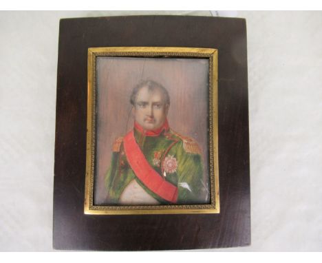 A hand painted portrait of Napoleon, wearing a green tunic with red sash, mounted to a brass and hardwood frame, 11cm x 8.5cm