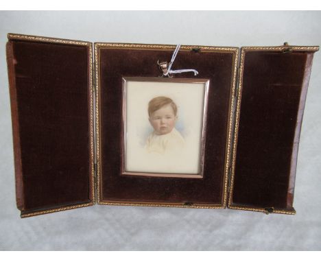 A rectangular gilt framed portrait miniature of a young boy, probably on ivory, mounted to a velvet lined gilt tooled brown l