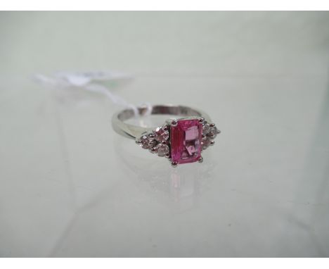 A pink sapphire and diamond half-hoop seven stone ring, the claw mounted stepped cut sapphire with three stone diamond should