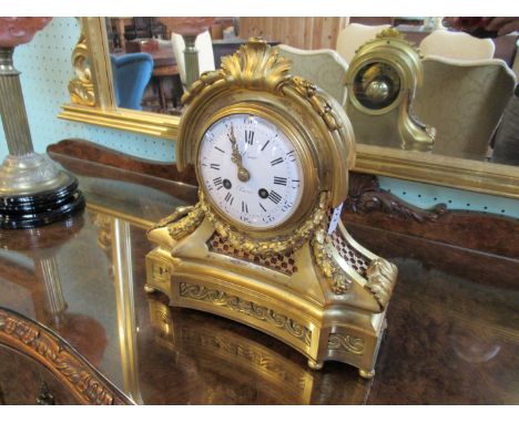 A 19th century French ormolu mantle clock, having acanthus leaf decoration, the circular enamel dial bearing Roman and Arabic