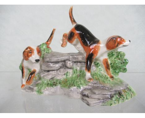 A Booth Derby hand painted ceramic figure group of two hounds, 19cm wide.