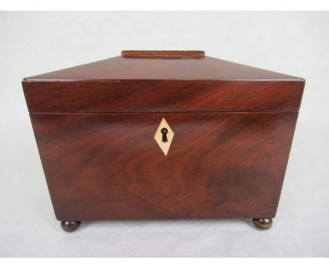 A Georgian rosewood tea caddy of sarcophagus form, having twin internal compartments and inset ivory escutcheon on four ball 