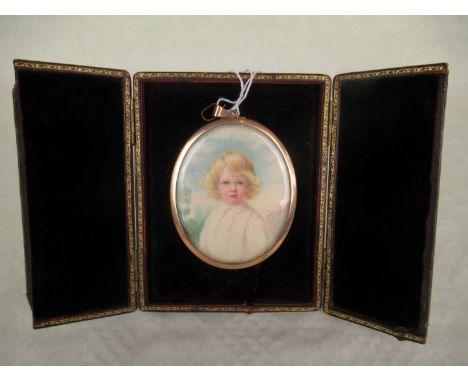 An Edwardian portrait miniature of a young child, bearing the monogram JMM, the oval portrait in a brass frame and mounted to