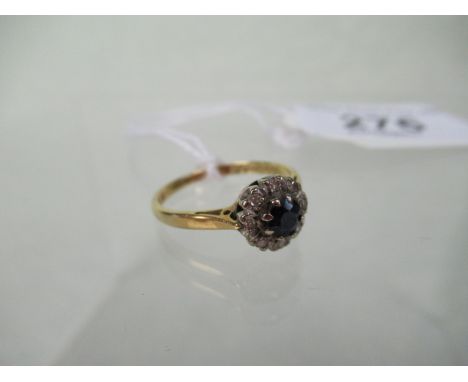 A sapphire and diamond cluster ring, the circular cut sapphire within a border of single cut diamonds to an 18ct gold shank.