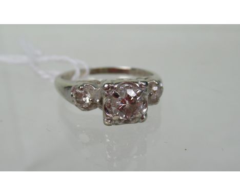 A three stone diamond half-hoop ring, the graduated brilliant cut diamonds in shaped, raised claw mounts to a plain shank. Co