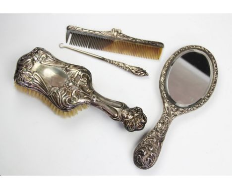 A selection of Art Nouveau silver dressing table wares comprising; a silver backed hand mirror, J & R Griffin, Chester 1905, 