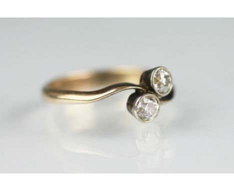 A two stone diamond cross-over ring, the two old brilliant cut diaomnds (each of approx 0.20ct) collet set within cross-over 