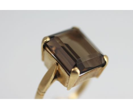 A smokey quartz set dress ring, the large, rectangular cut quartz, within four claw setting to the plain hoop, all set in 9ct