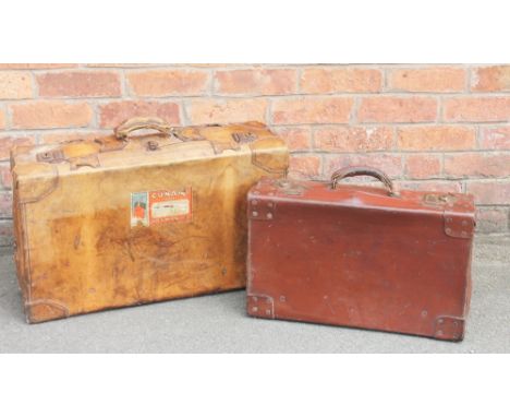 A tan leather suit case, with Cunard Line vintage labels, 21cm H x 70cm W x 41cm D, with a smaller suit case and vintage text