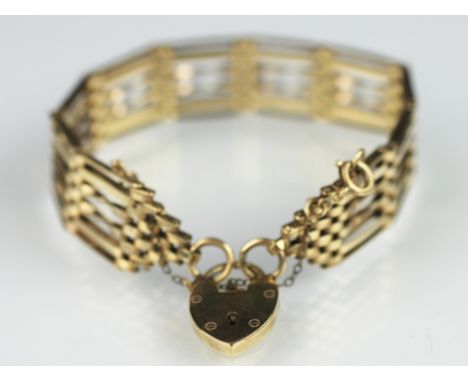 A 9ct yellow gold six bar gate style bracelet, with central 'twist' bar and attached padlock clasp and safety chain, weight 1