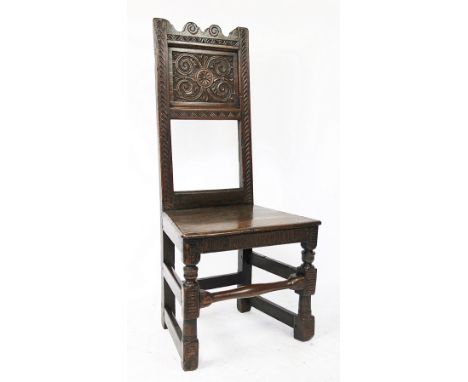 An 18th century provincial oak chair, with panelled back and solid seat, on turned and block legs, later carving, 103cm H, wi